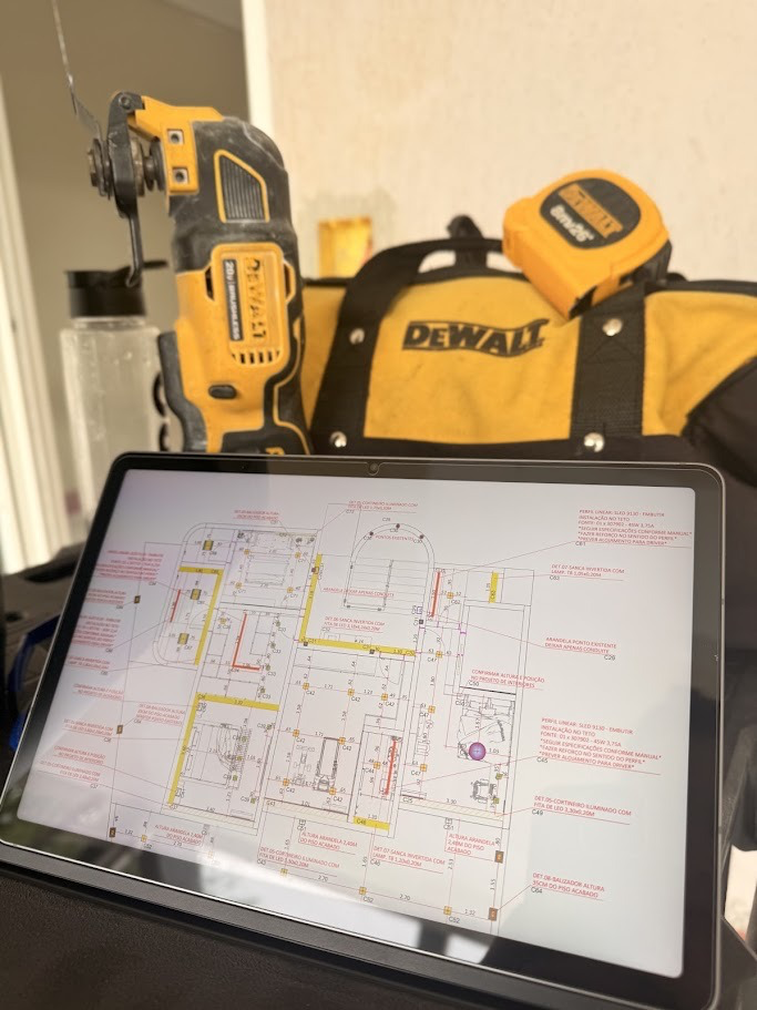 Projeto elétrico e de automação aberto no tablet ao lado das ferramentas